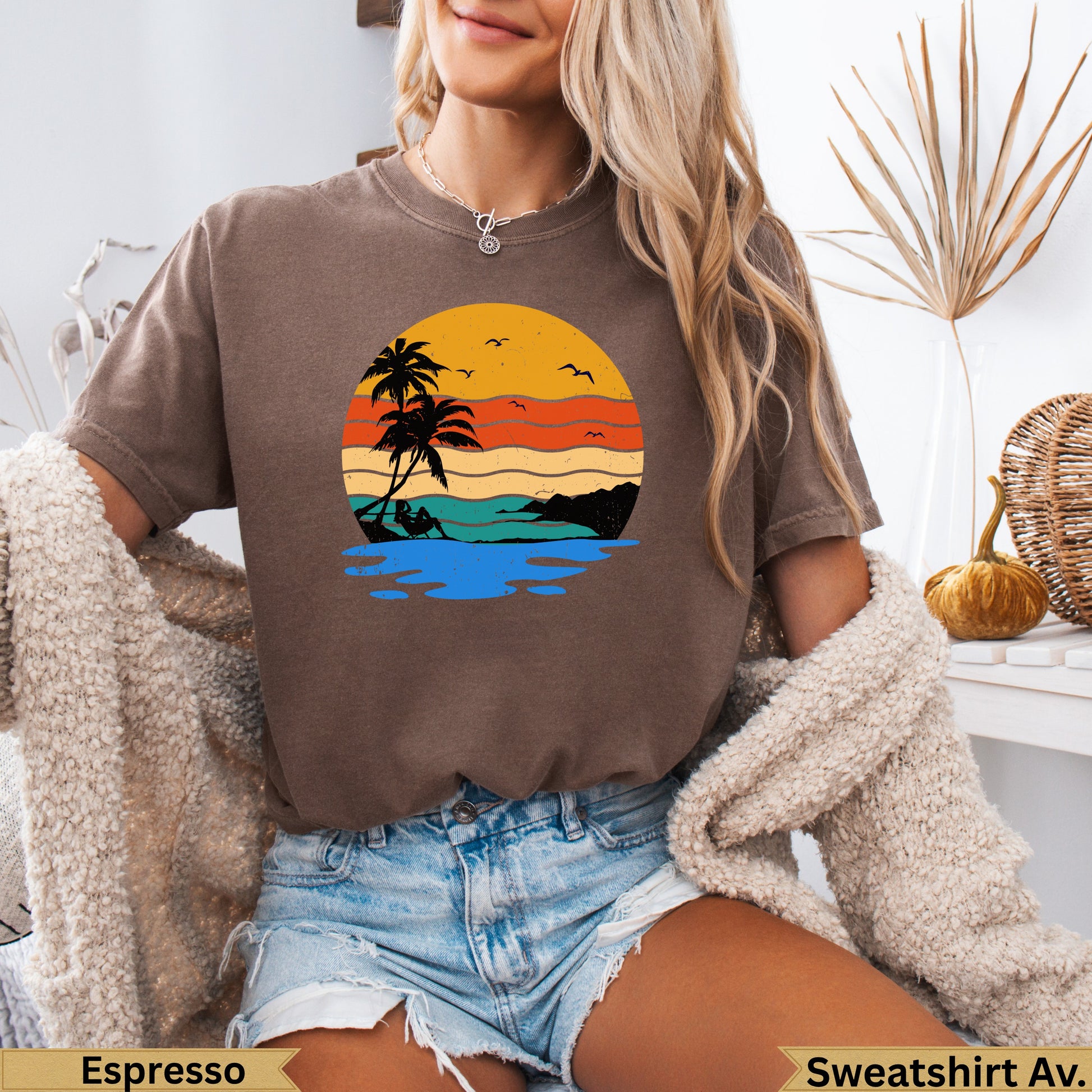 Brown t-shirt with a sunset beach scene featuring palm trees and water.