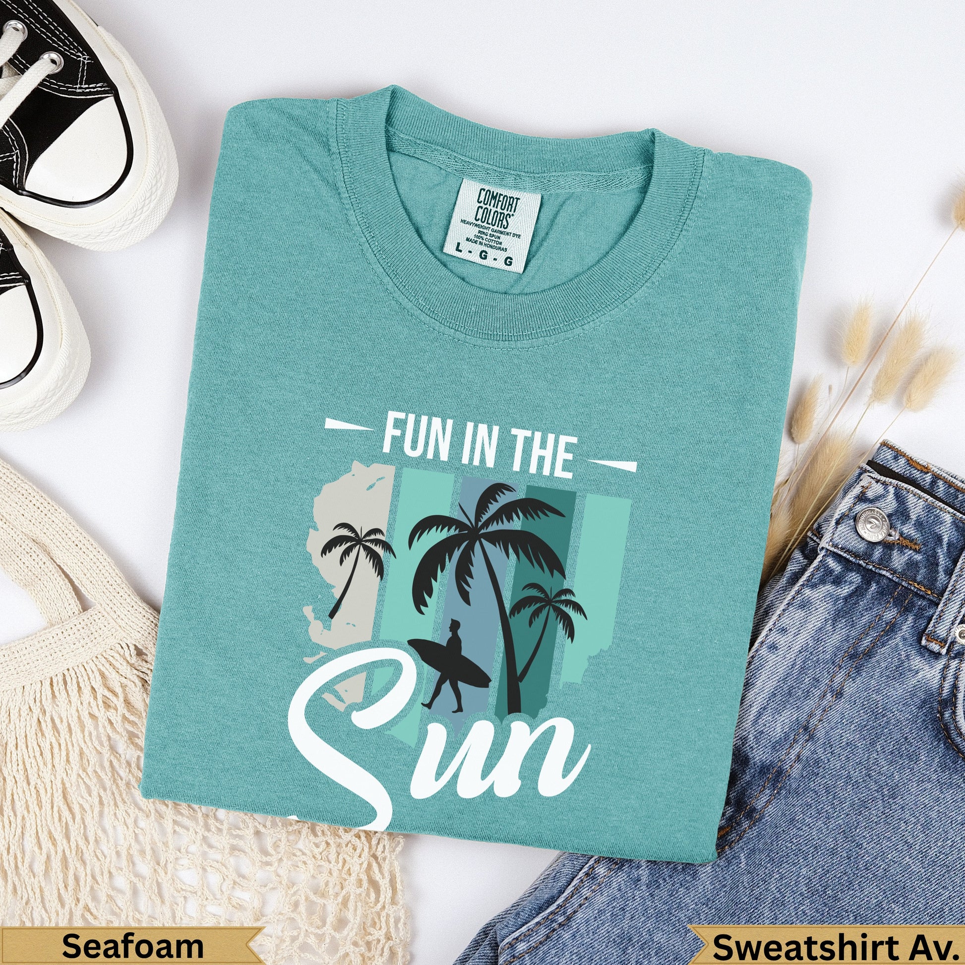 Teal "Fun in the Sun" graphic tee with palm trees and a surfboard.