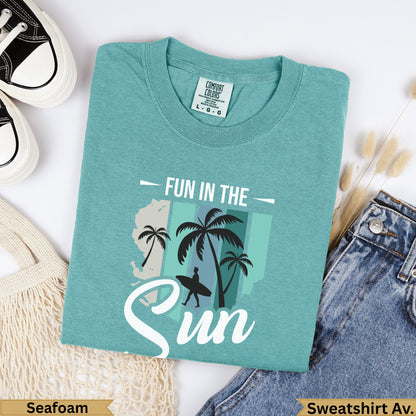 Teal "Fun in the Sun" graphic tee with palm trees and a surfboard.