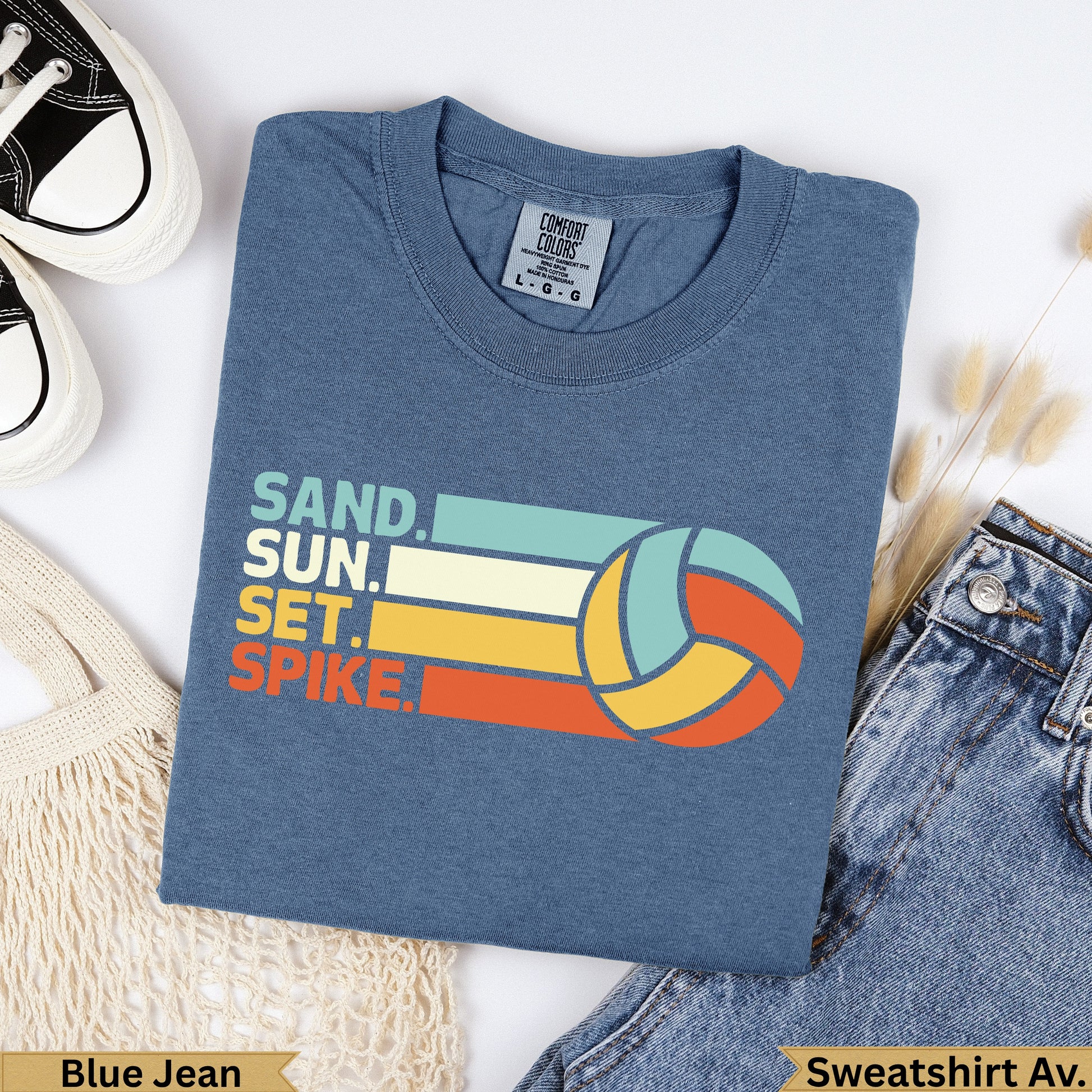 Blue t-shirt with "SAND. SUN. SET. SPIKE." and volleyball graphic.