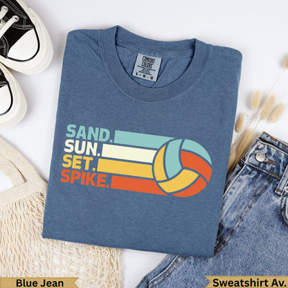 Blue t-shirt with "SAND. SUN. SET. SPIKE." and volleyball graphic.
