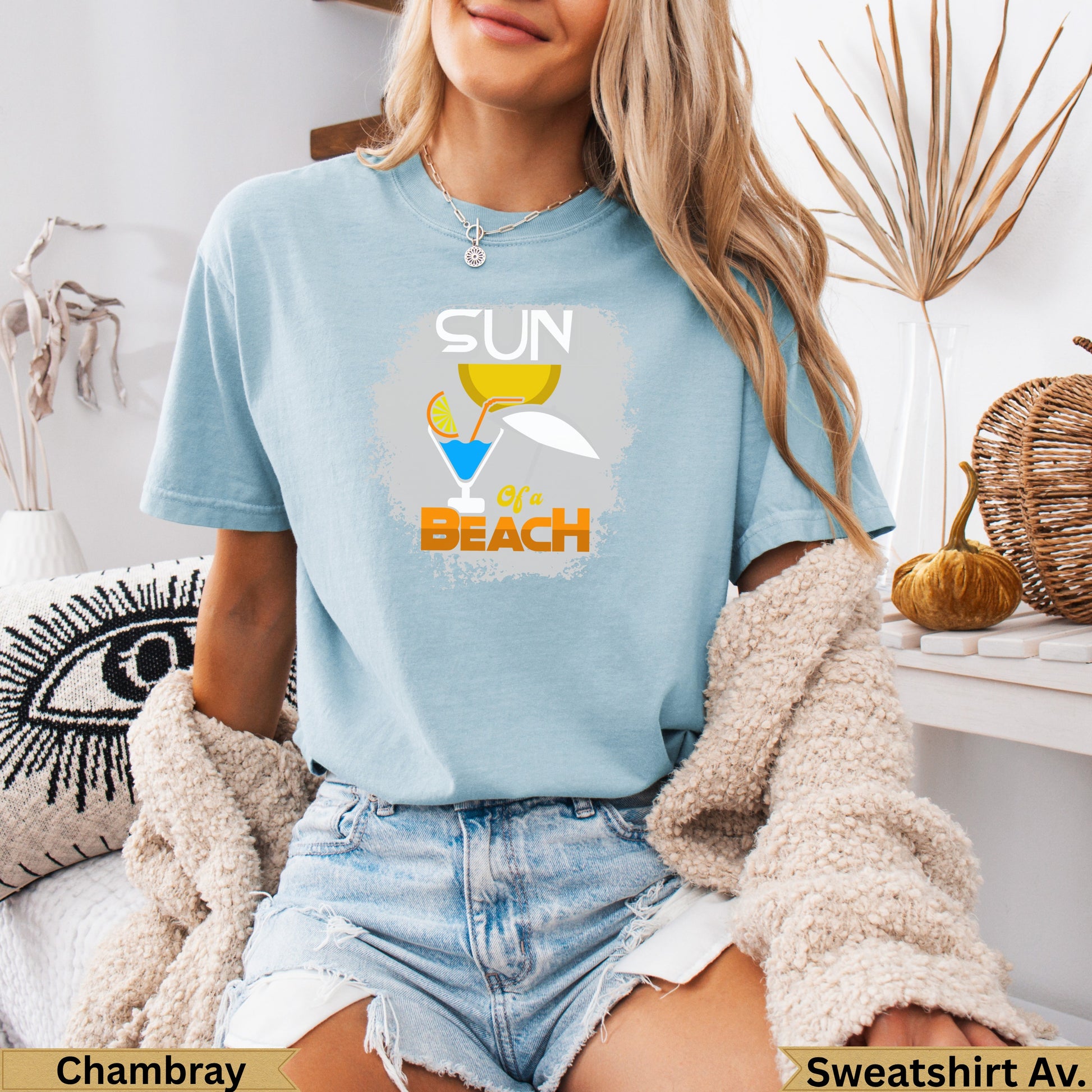 Light blue t-shirt with "Sun of a Beach" graphic featuring a cocktail and umbrella.