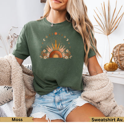 Green t-shirt with sun, moon, and floral graphic print.