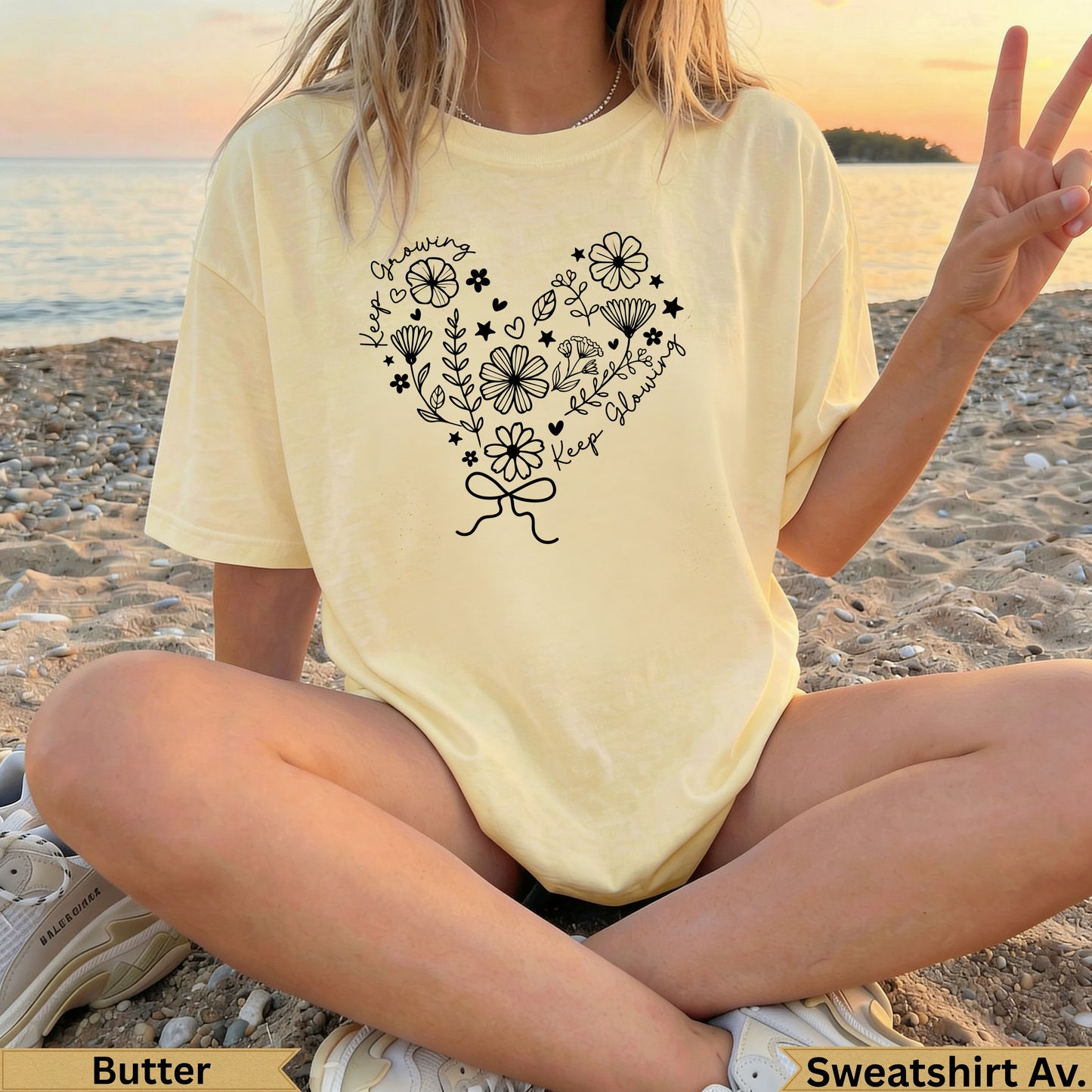 Pale yellow t-shirt with heart design of flowers, leaves, and bow, "Keep Growing".