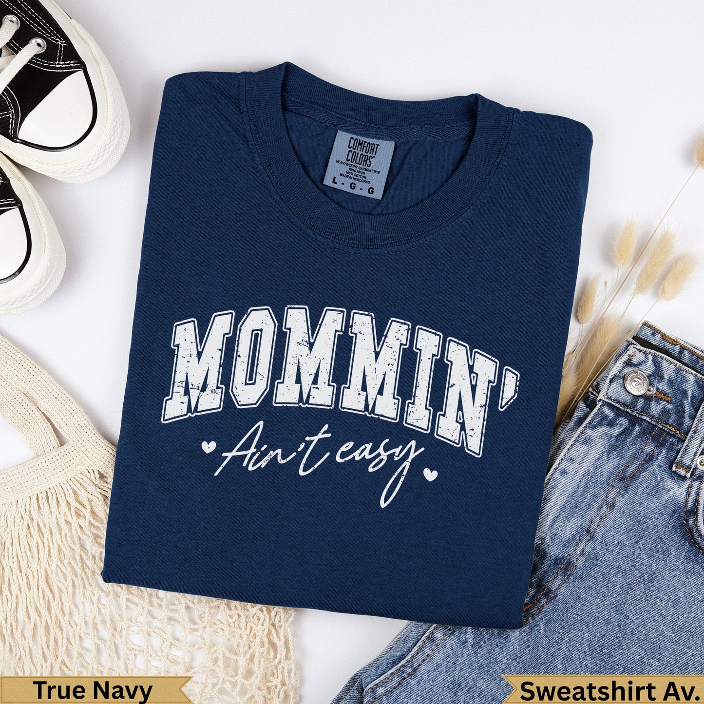 Navy Comfort Colors sweatshirt with "MOMMIN' Ain't easy." graphic.