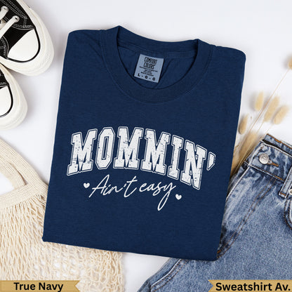 Navy Comfort Colors sweatshirt with "MOMMIN' Ain't easy." graphic.