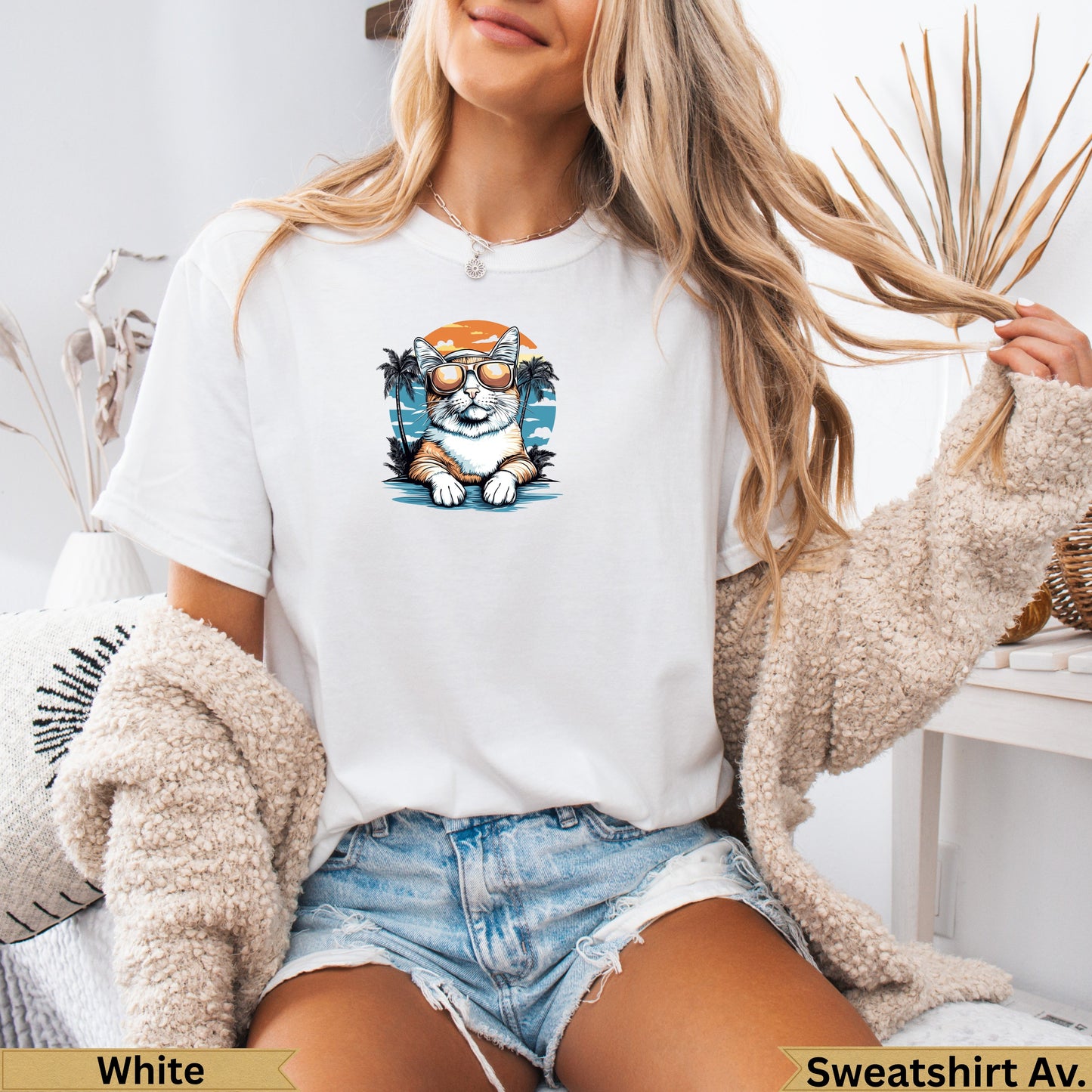 White t-shirt with graphic of cat in sunglasses by a beach.