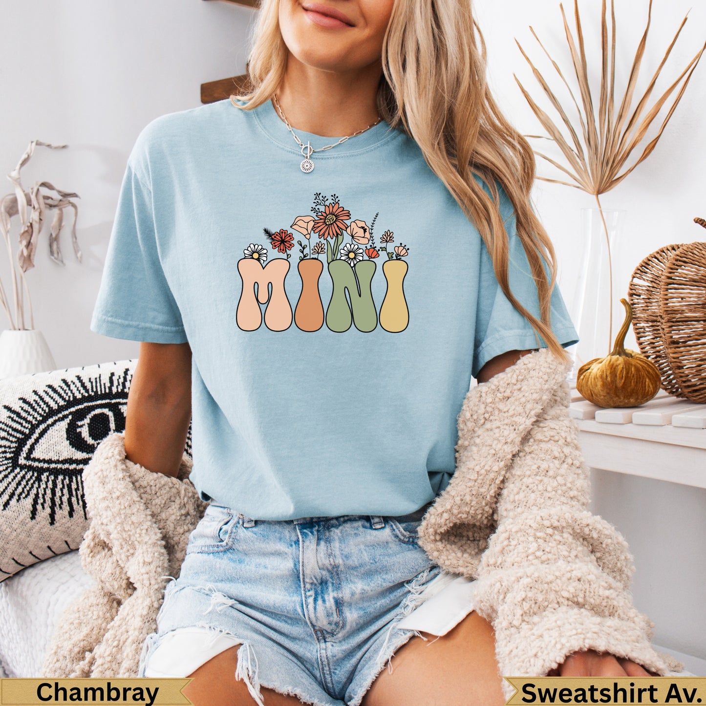 Light blue t-shirt with "MINI" spelled out in colorful, retro lettering and floral accents.