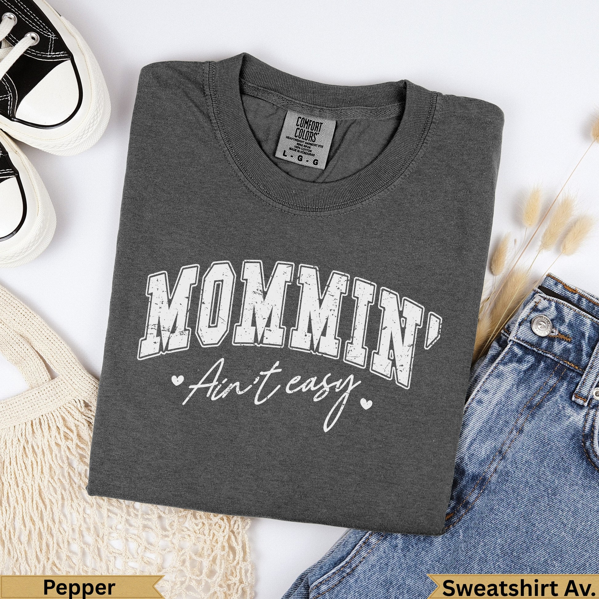 Dark grey graphic sweatshirt with "MOMMIN' Ain't easy." text.