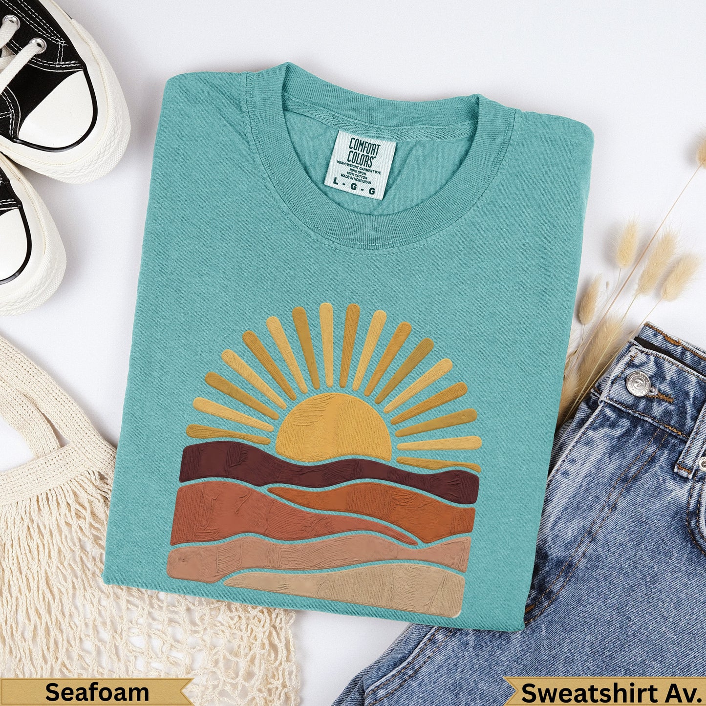 Teal Comfort Colors sweatshirt with sun and layered earth tones, labeled Seafoam.