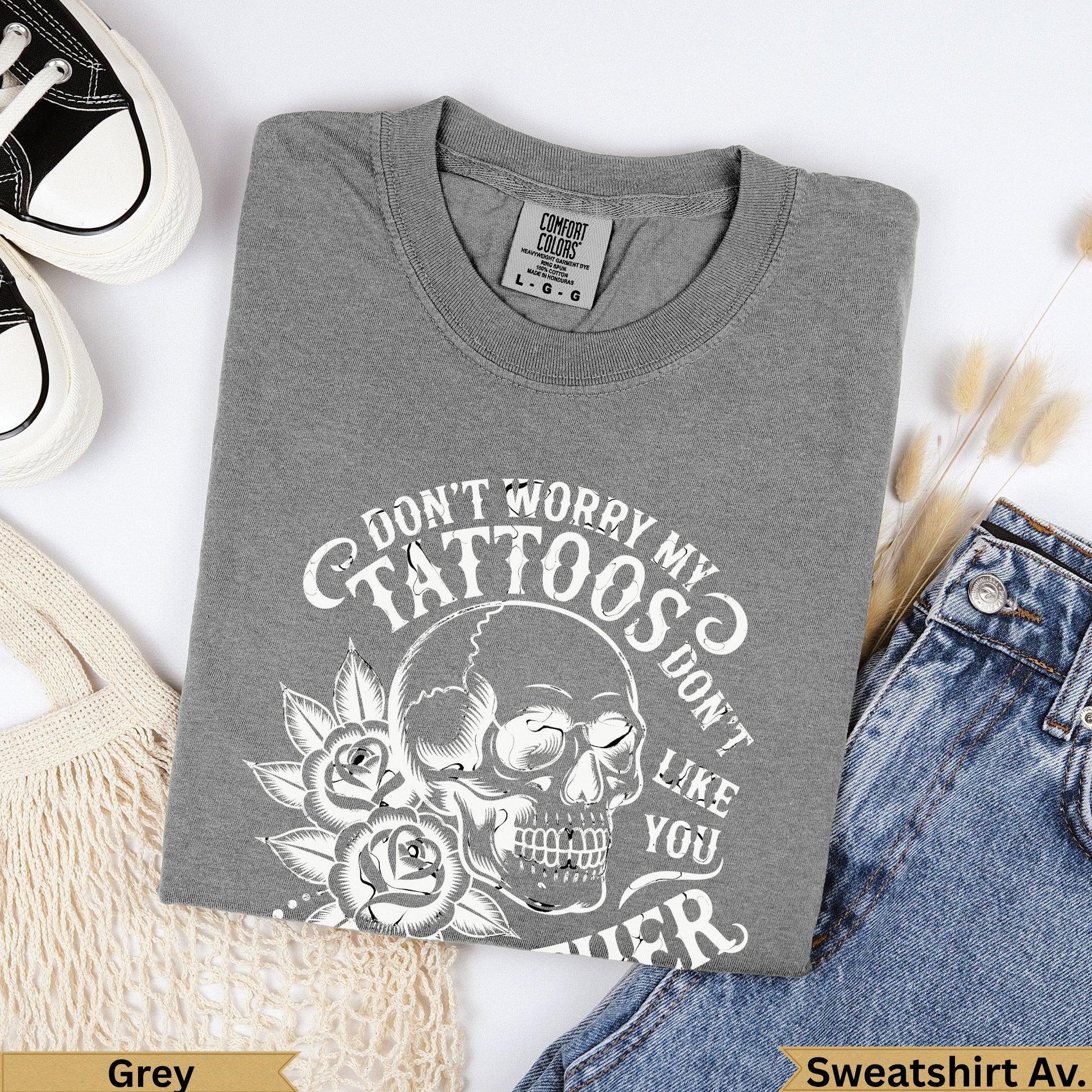 Grey crewneck sweatshirt with skull, roses, and "Don't worry my tattoos don't like you either" text.