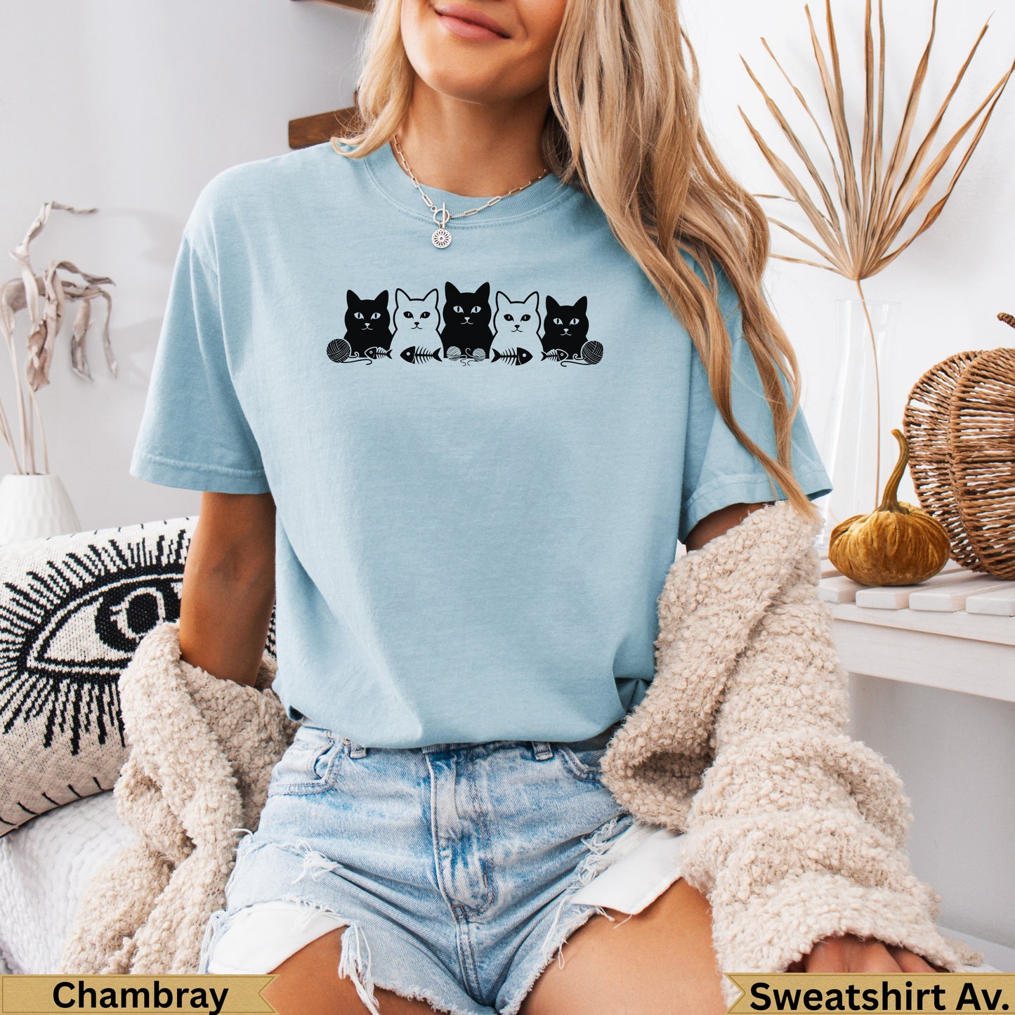 Light blue t-shirt with a row of four black cats wearing bow ties.
