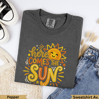 Dark grey t-shirt with "here comes the sun" text and smiling sun graphic.