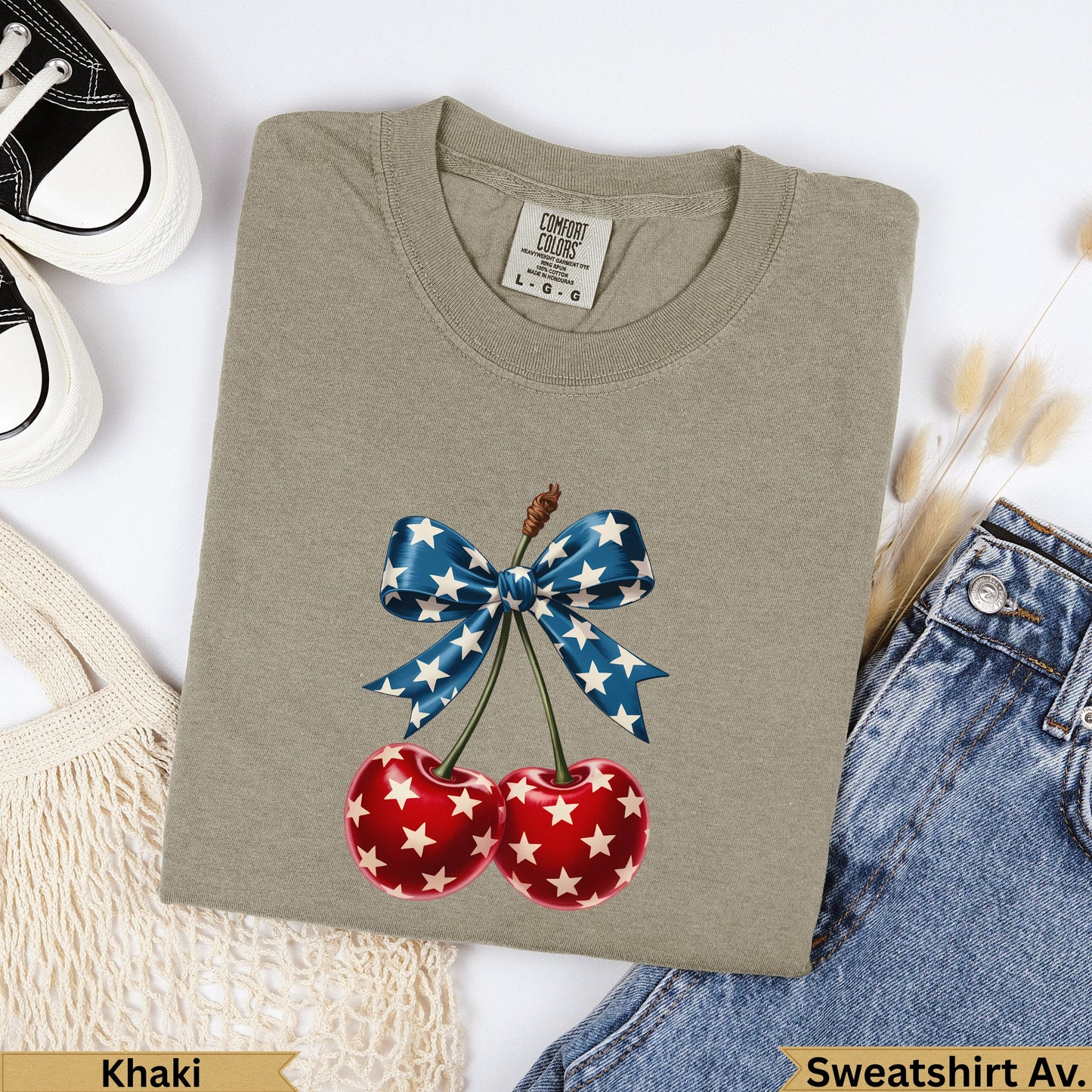 Khaki sweatshirt with a red cherry graphic and a blue star-spangled bow.