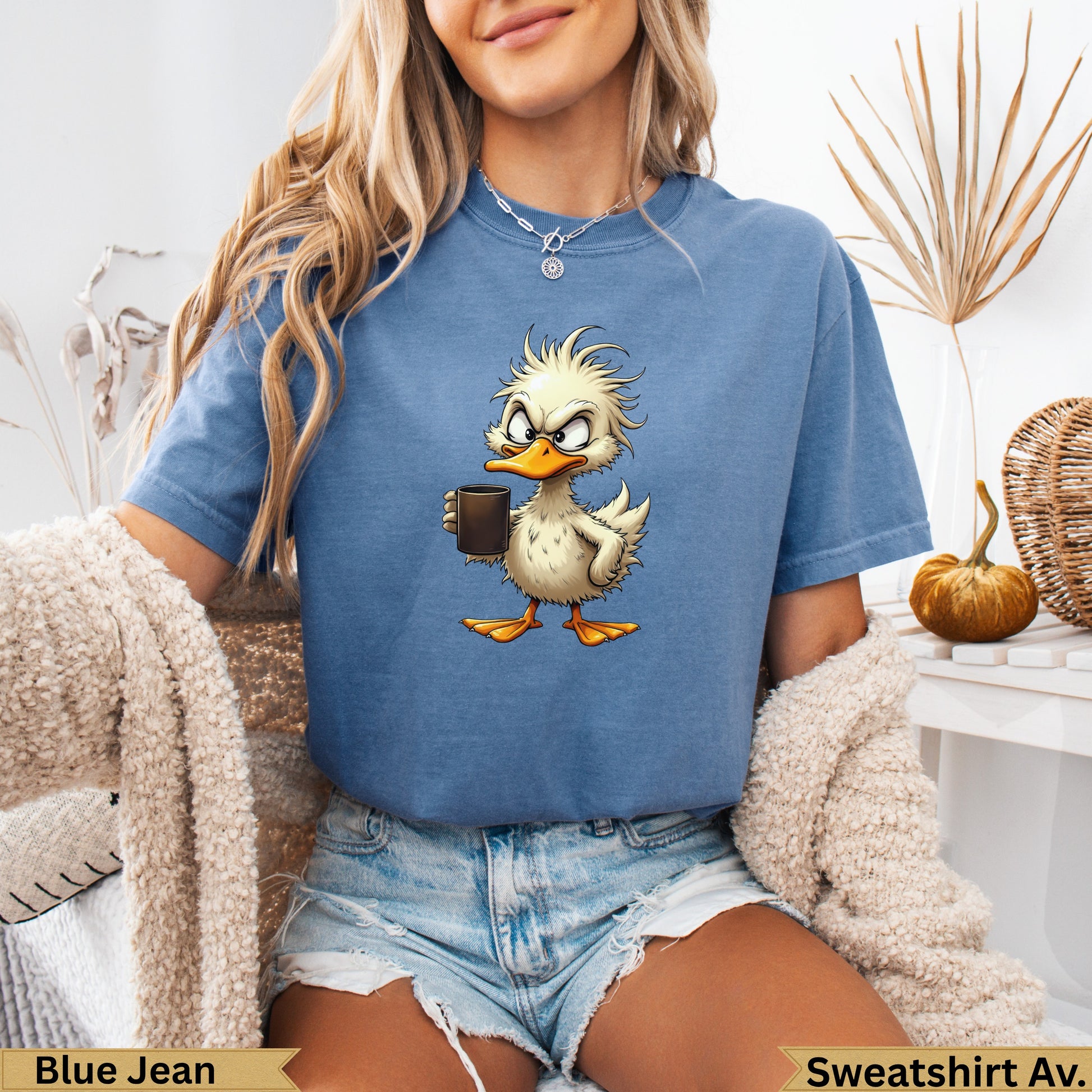 Cartoon duck with coffee cup and ruffled feathers on blue t-shirt.