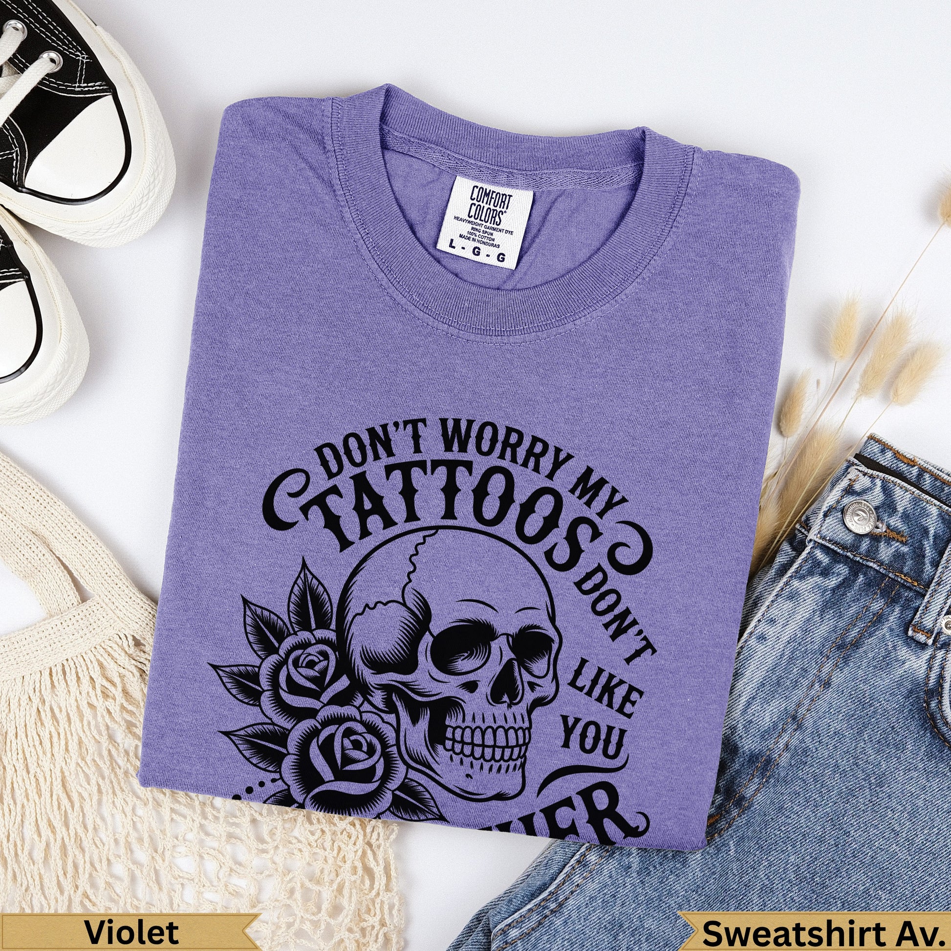 Purple graphic t-shirt with skull and roses design reading "Don't Worry My Tattoos Don't Like You".