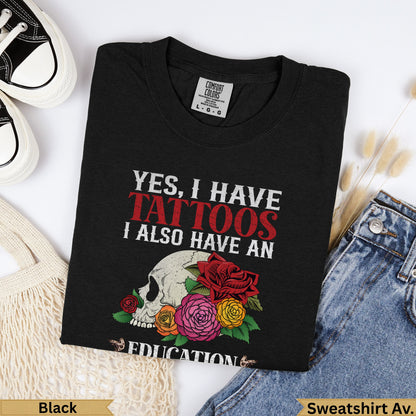 Black t-shirt with skull, roses, and text "Yes, I have tattoos. I also have an education."