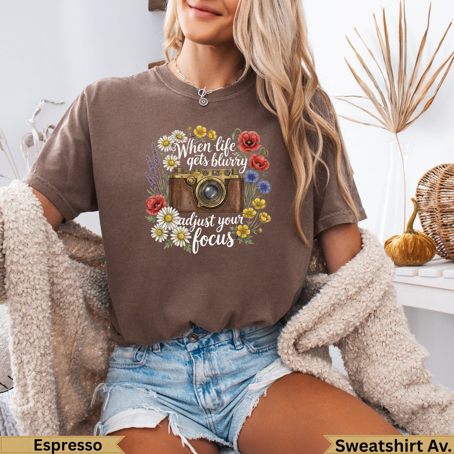 Brown t-shirt with vintage camera and floral graphic with text.