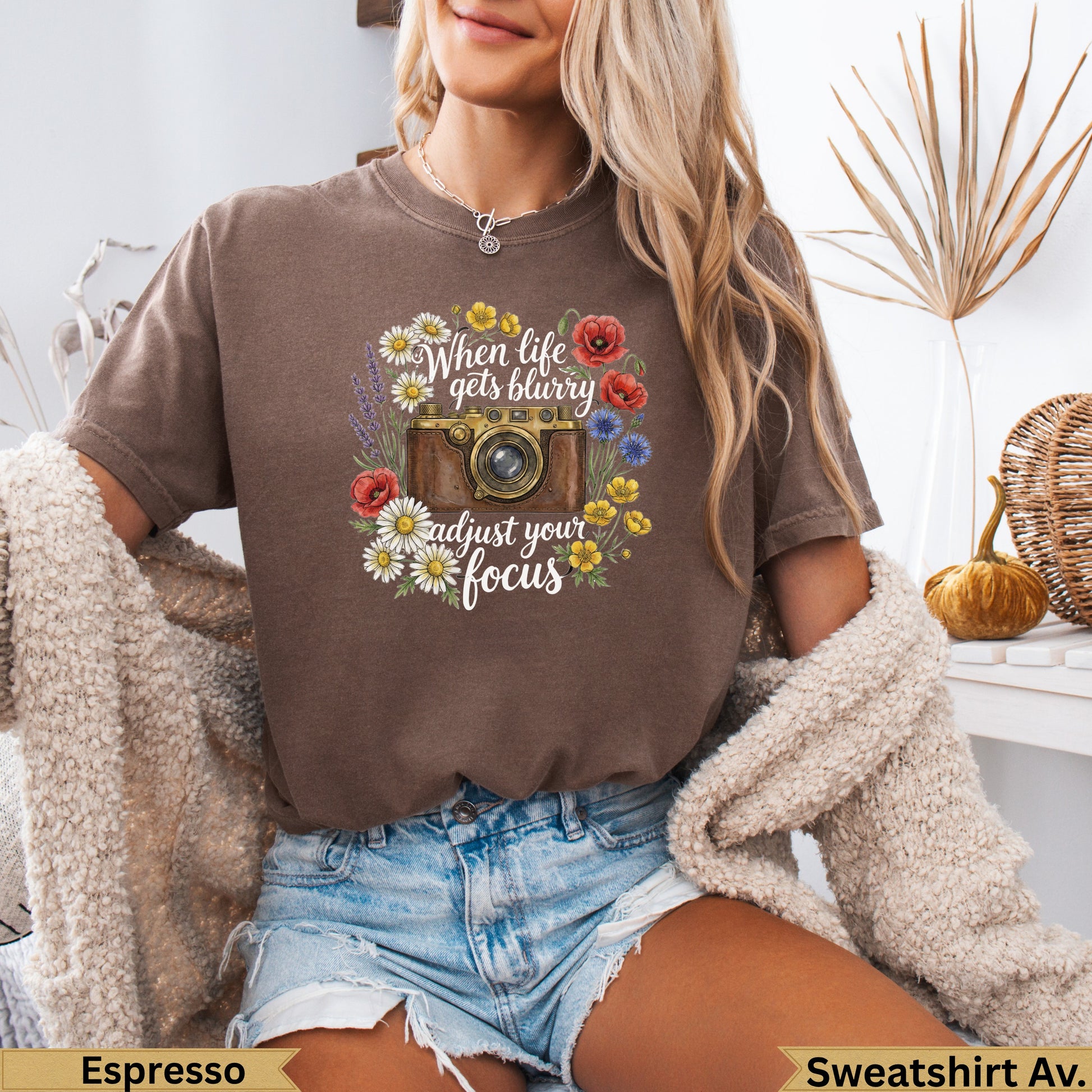 Brown t-shirt with vintage camera and floral graphic with text.