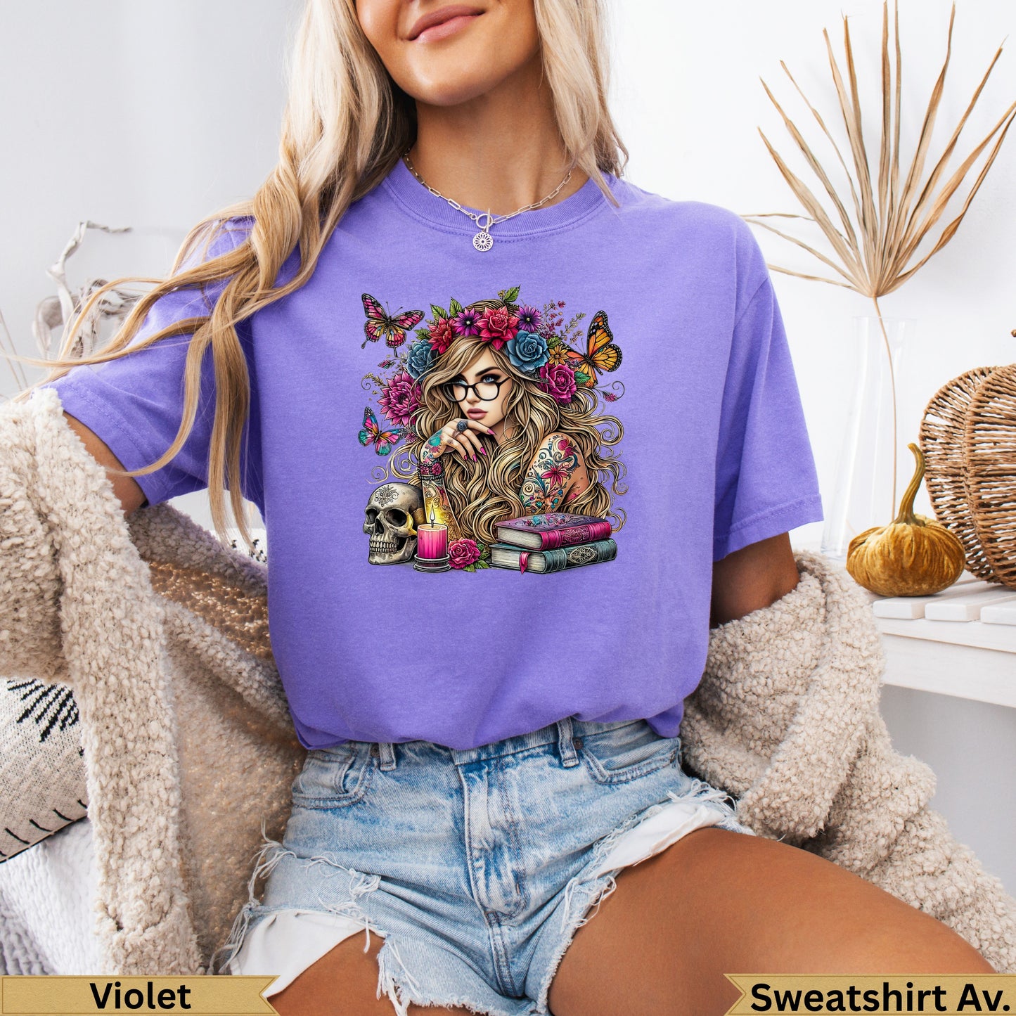 Woman wearing purple t-shirt with skull, flowers, and butterflies graphic.