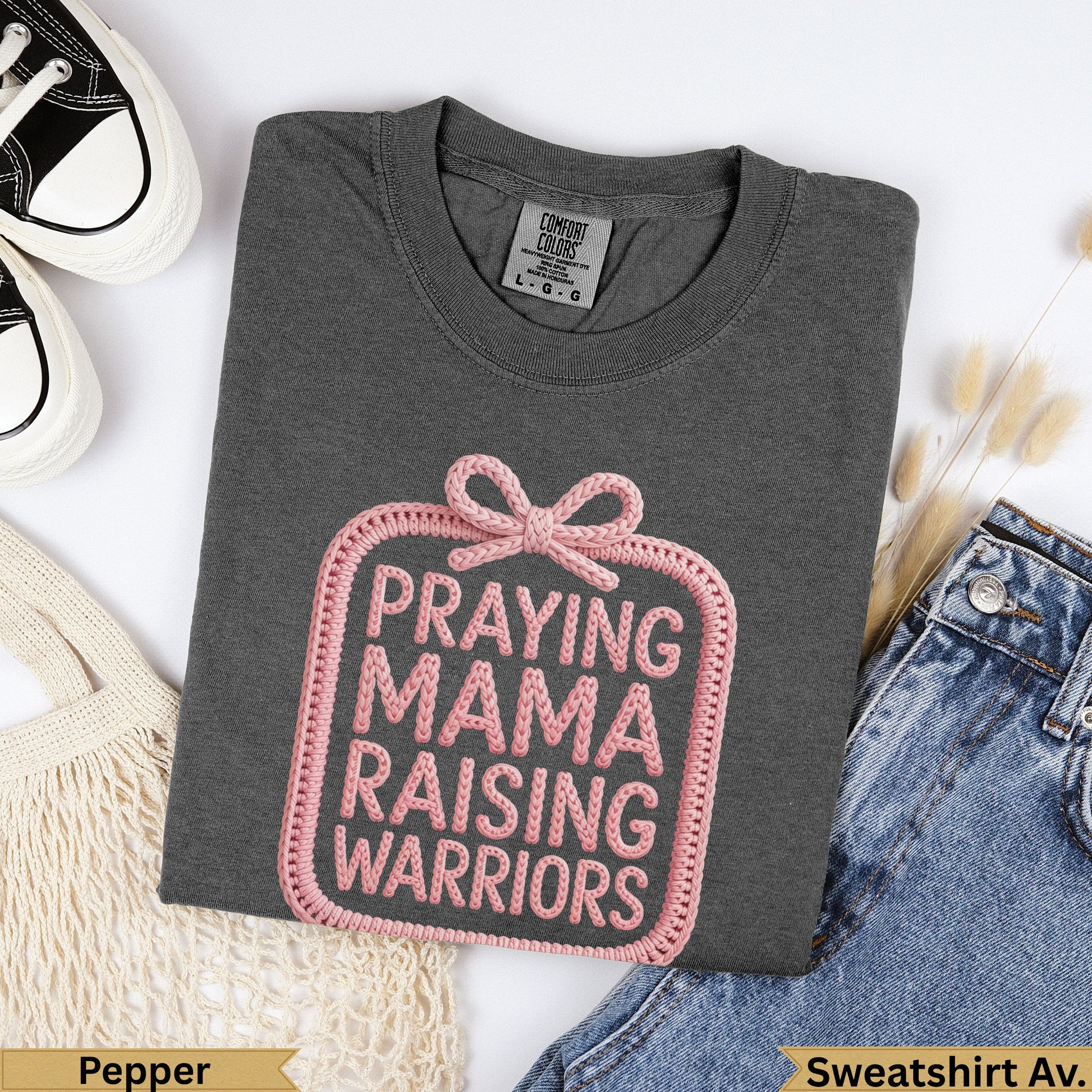 Dark grey sweatshirt with pink "Praying Mama Raising Warriors" graphic.