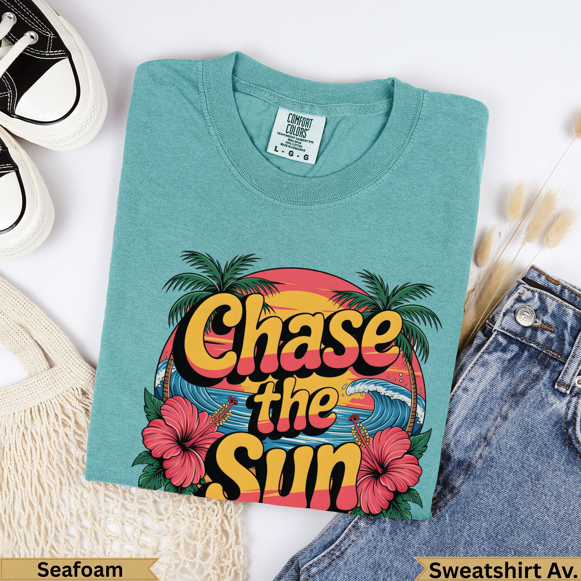 Teal t-shirt with "Chase the Sun" text, palm trees, and waves graphic.