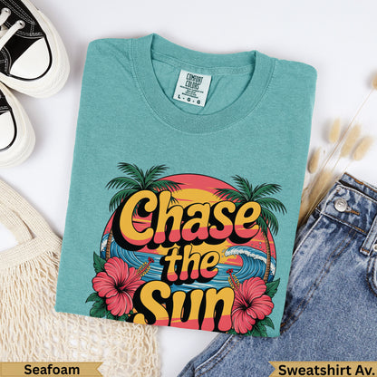 Teal t-shirt with "Chase the Sun" text, palm trees, and waves graphic.