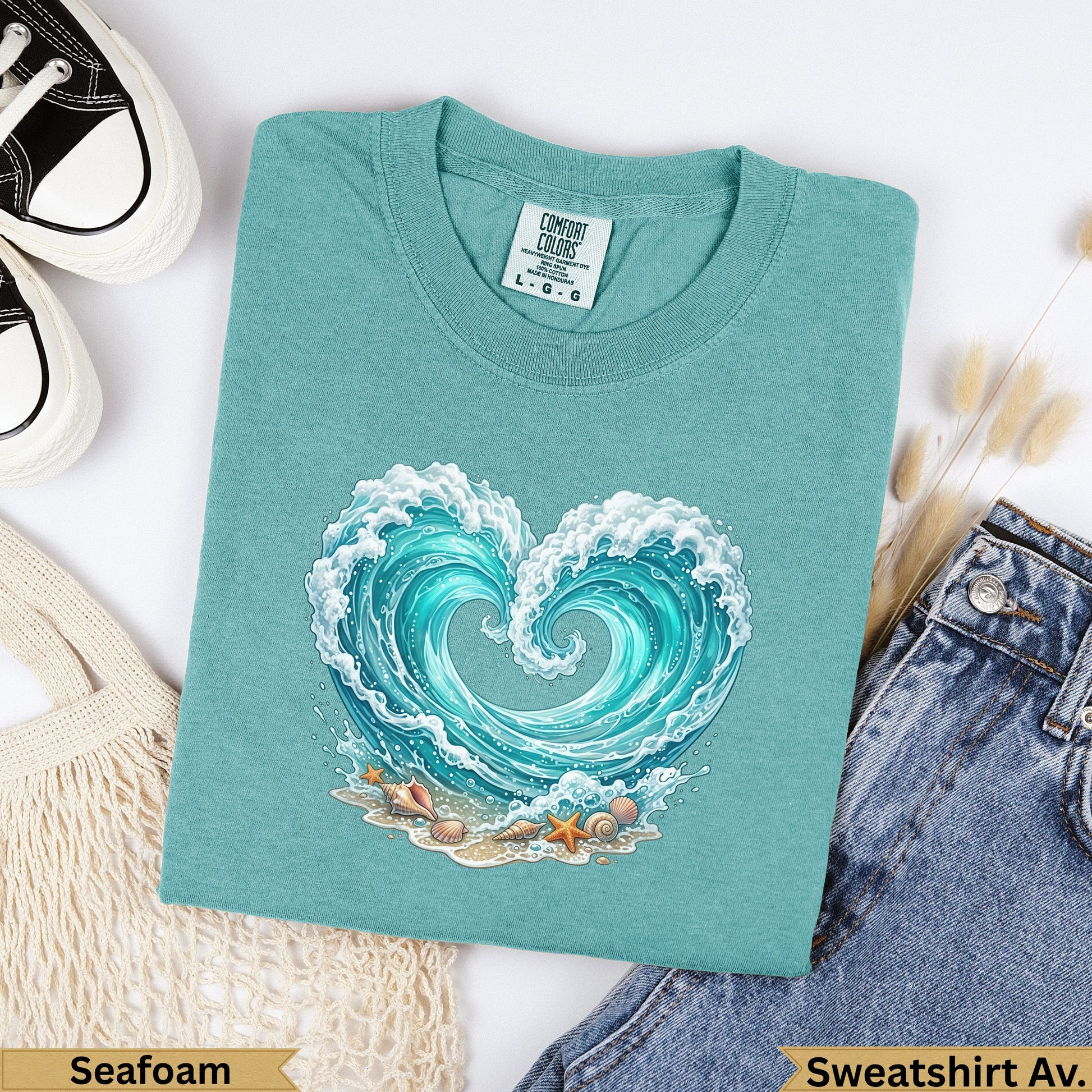 Teal t-shirt with a heart-shaped ocean wave graphic and "Seafoam" text.