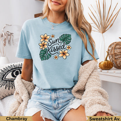 Light blue t-shirt with "Sun Kissed" text and floral tropical leaf graphic.