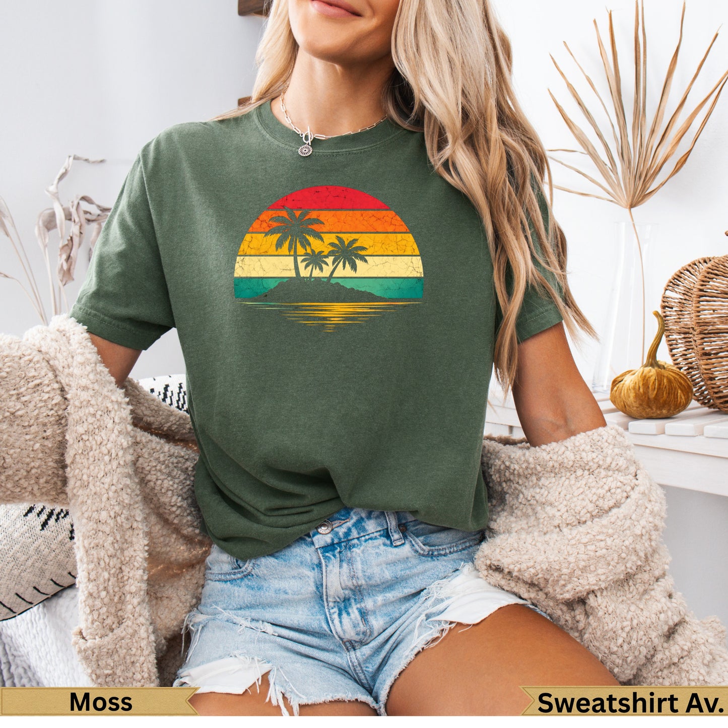 Green t-shirt with a retro sunset graphic of palm trees on an island.
