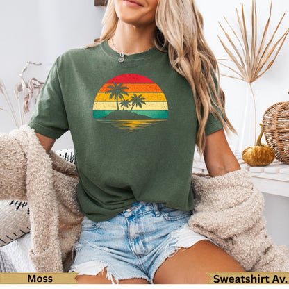 Green t-shirt with a retro sunset graphic of palm trees on an island.