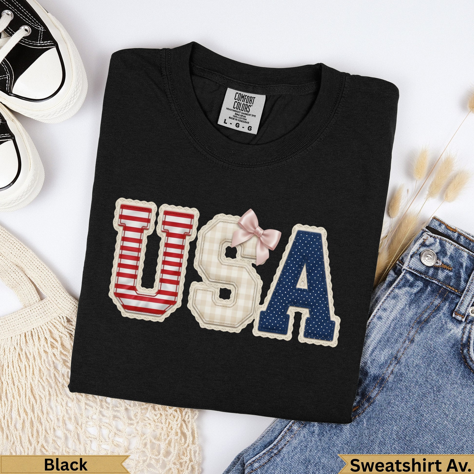 Black t-shirt with "USA" graphic made of patterned patches and a pink bow.