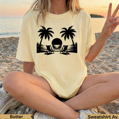 Pale yellow t-shirt with palm trees, beach chairs, and sunset graphic.