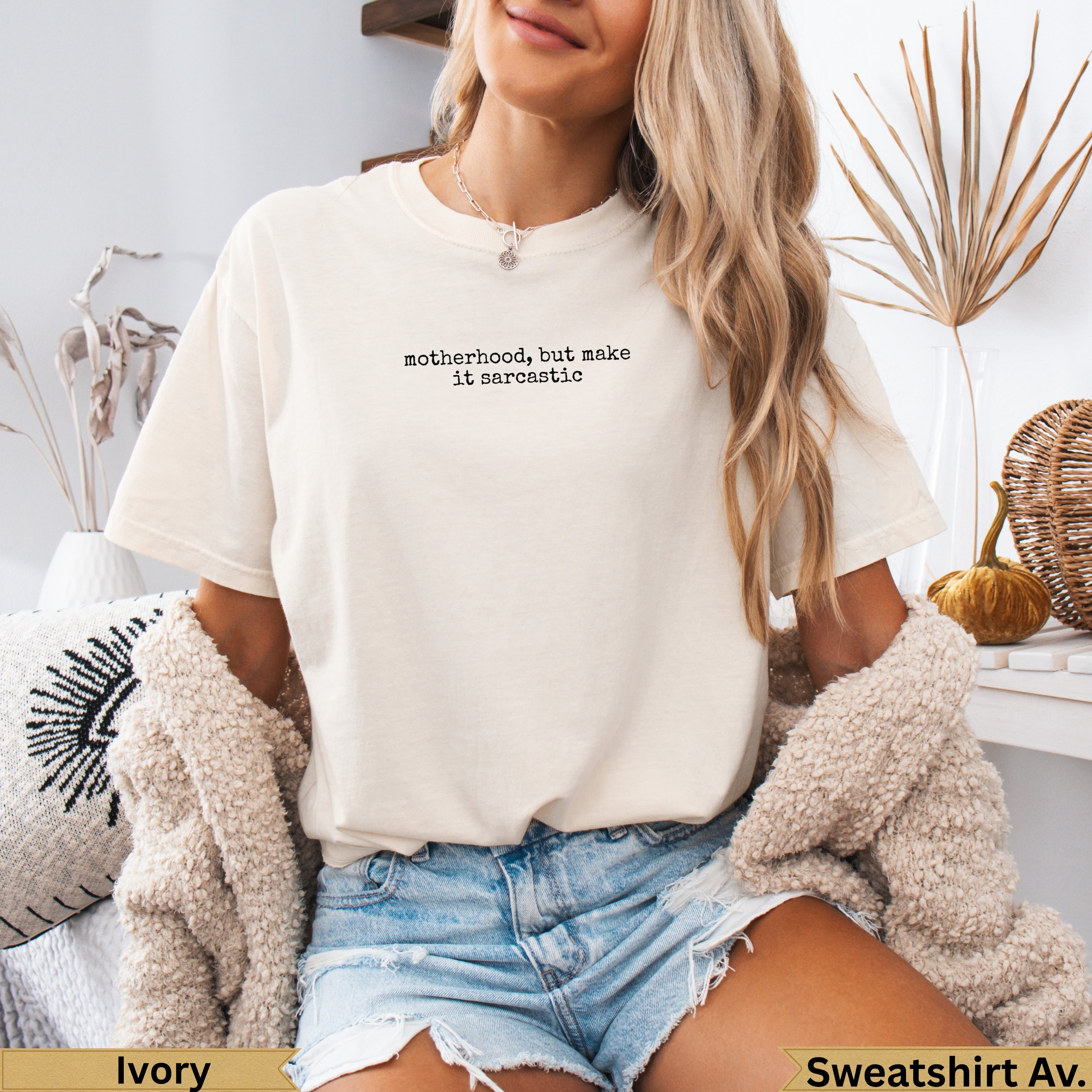 Cream t-shirt with "motherhood, but make it sarcastic" text, worn by a woman.