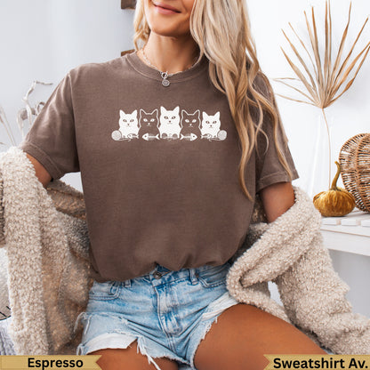 Brown t-shirt with row of white cartoon cats and fish bones print.