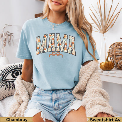 Light blue t-shirt with floral "MAMA" text and orange bow detail.