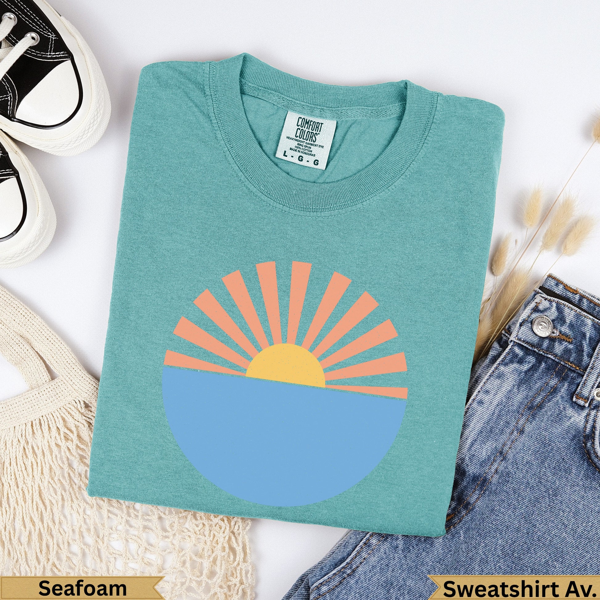 Teal Comfort Colors sweatshirt with sun and ocean graphic, "Seafoam" label.