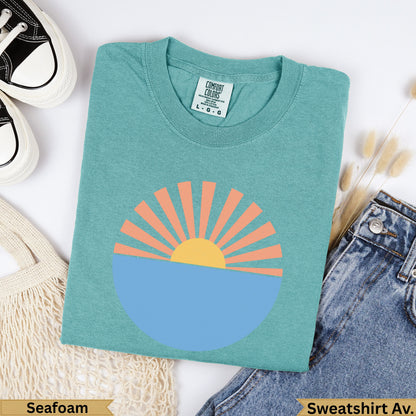 Teal Comfort Colors sweatshirt with sun and ocean graphic, "Seafoam" label.