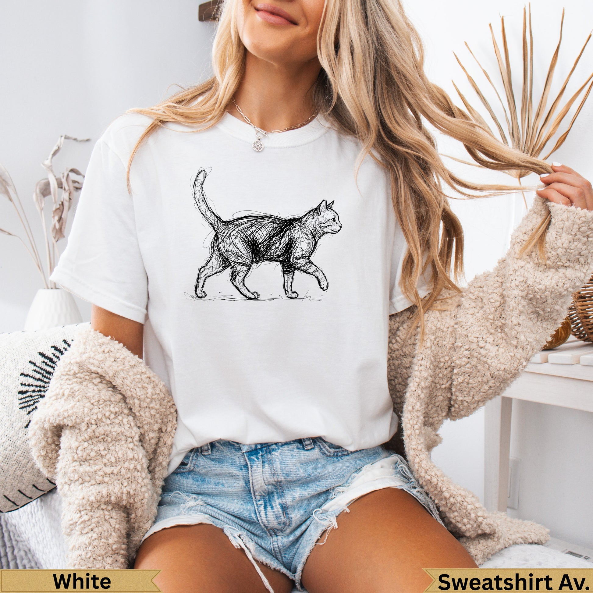 White t-shirt with a sketched black cat design, modeled by a woman.