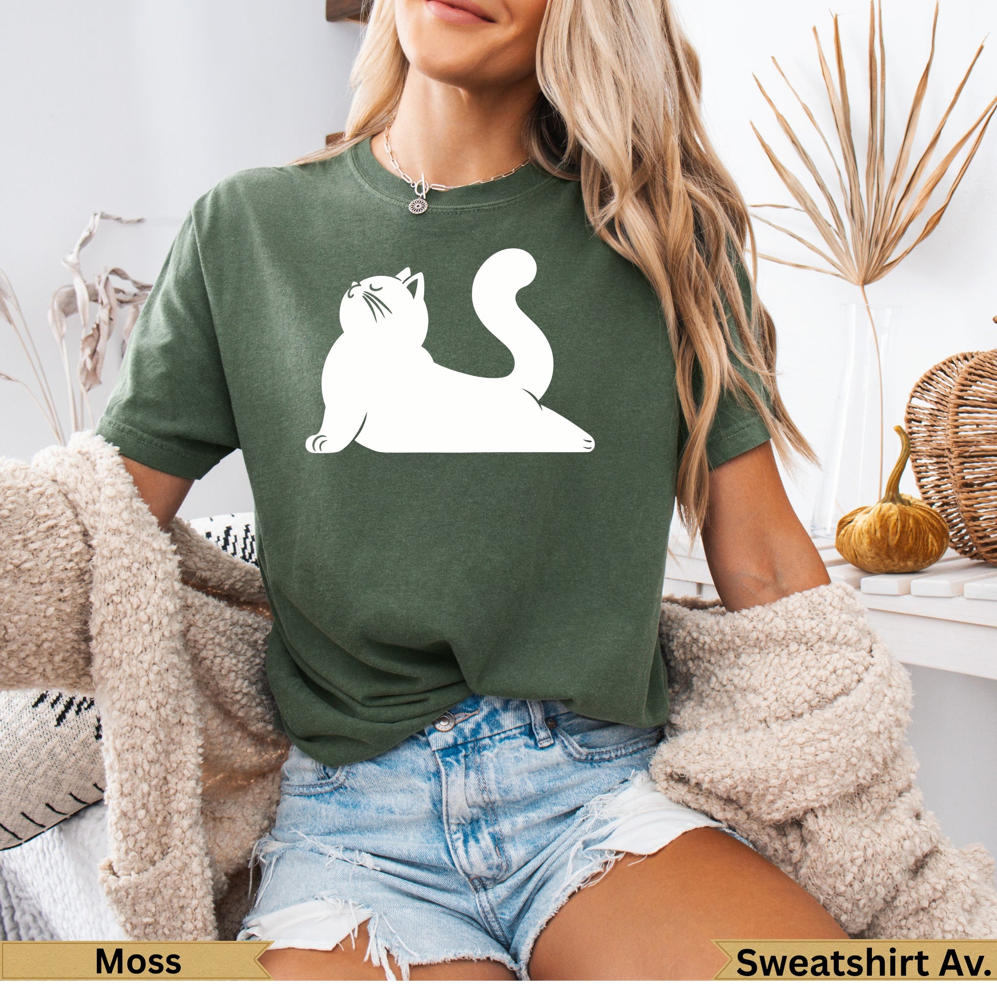 Green t-shirt with white cat silhouette, worn by a woman.