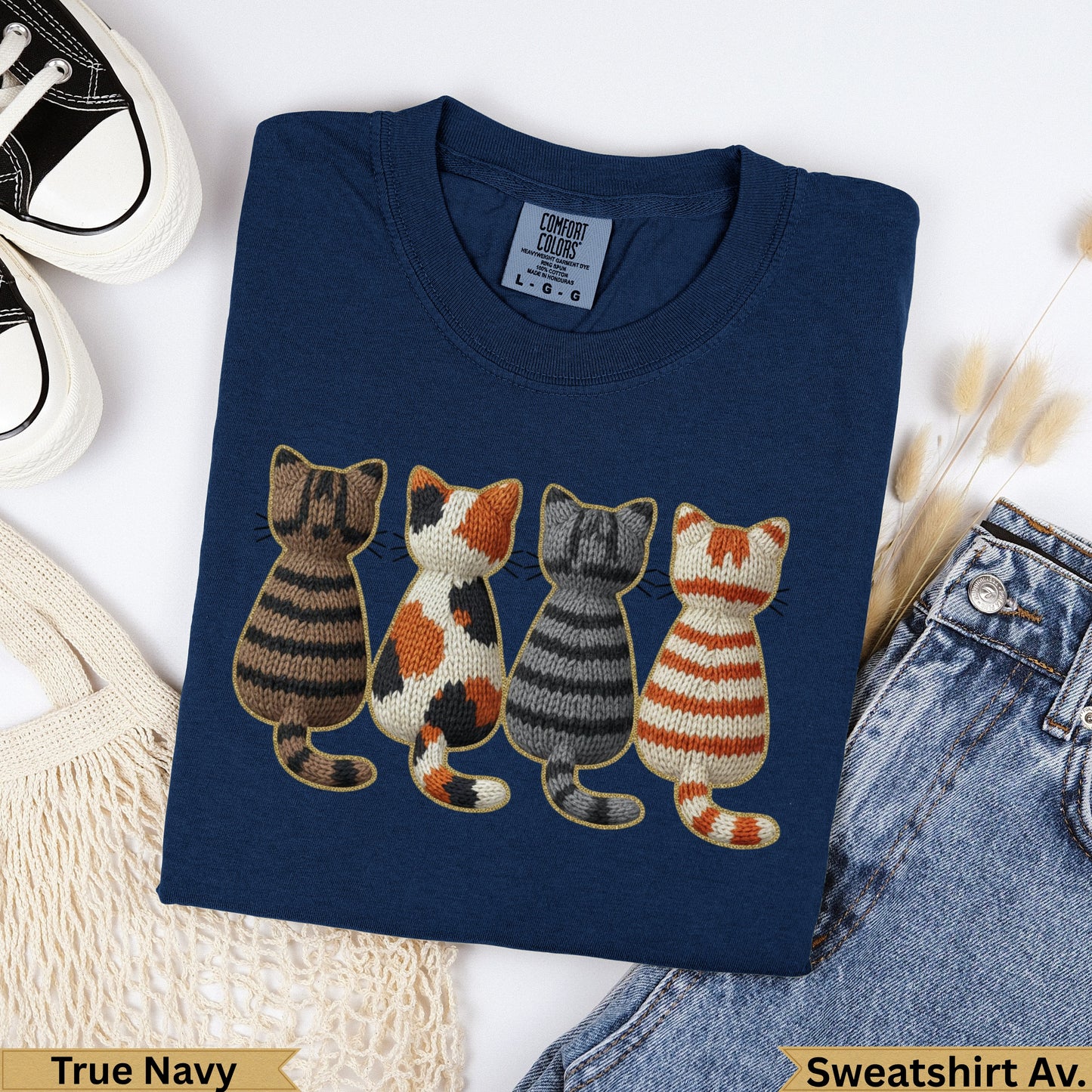 Navy sweatshirt with four embroidered cats in stripe and polka dot patterns.