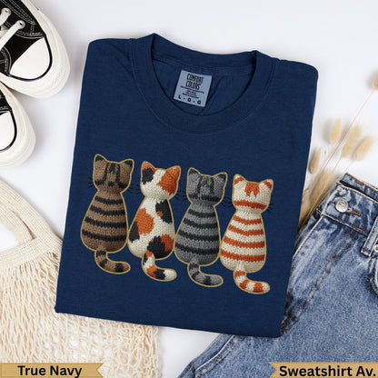 Navy sweatshirt with four embroidered cats in stripe and polka dot patterns.