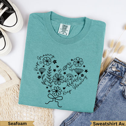 Teal Comfort Colors sweatshirt with black floral heart design and "Keep Growing, Keep Glowing" text.