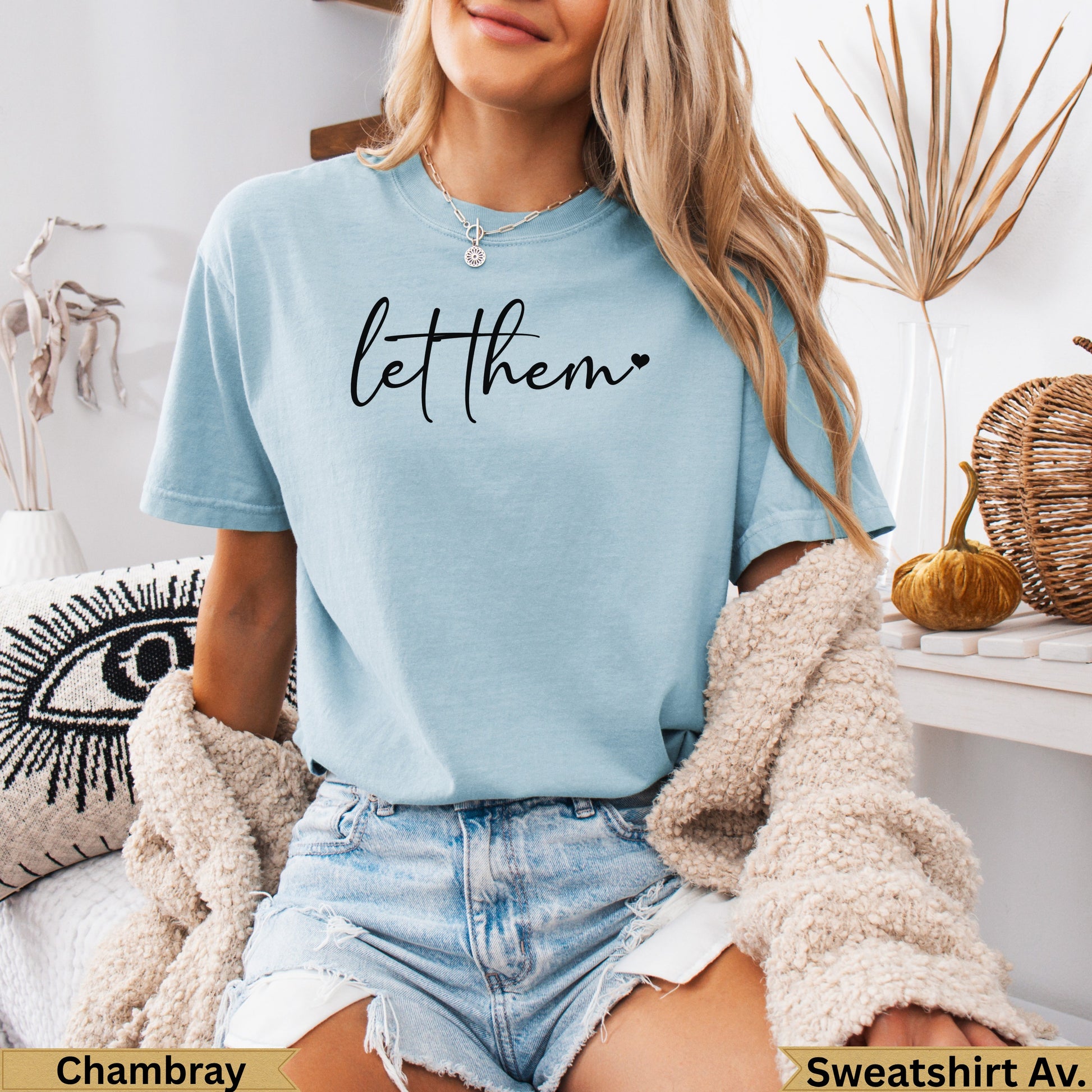 Light blue t-shirt with "let them" text and heart graphic.