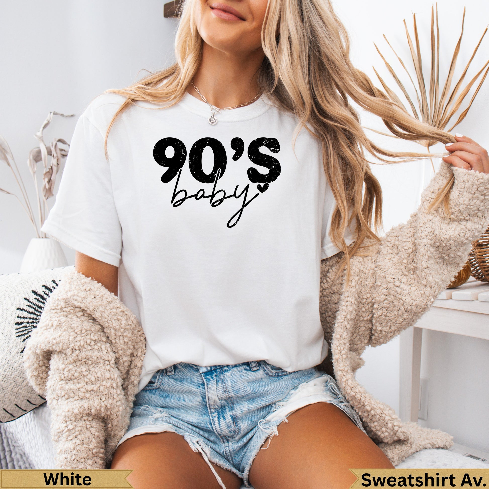 White t-shirt with "90's baby" text, worn by a woman.