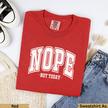 Red crewneck t-shirt with "NOPE NOT TODAY" graphic, laid flat with jeans.