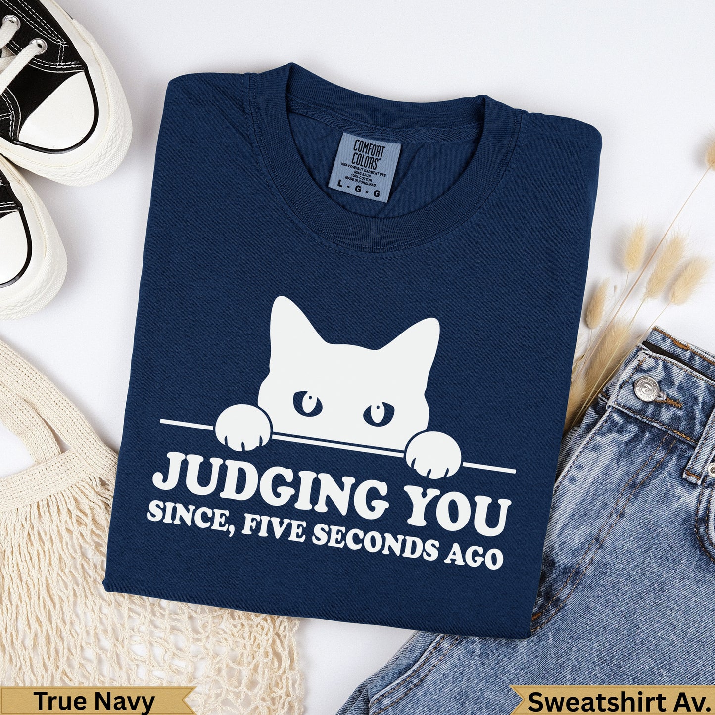 Navy blue graphic sweatshirt with white cat peeking over text "Judging You".