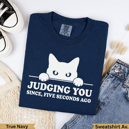 Navy blue graphic sweatshirt with white cat peeking over text "Judging You".