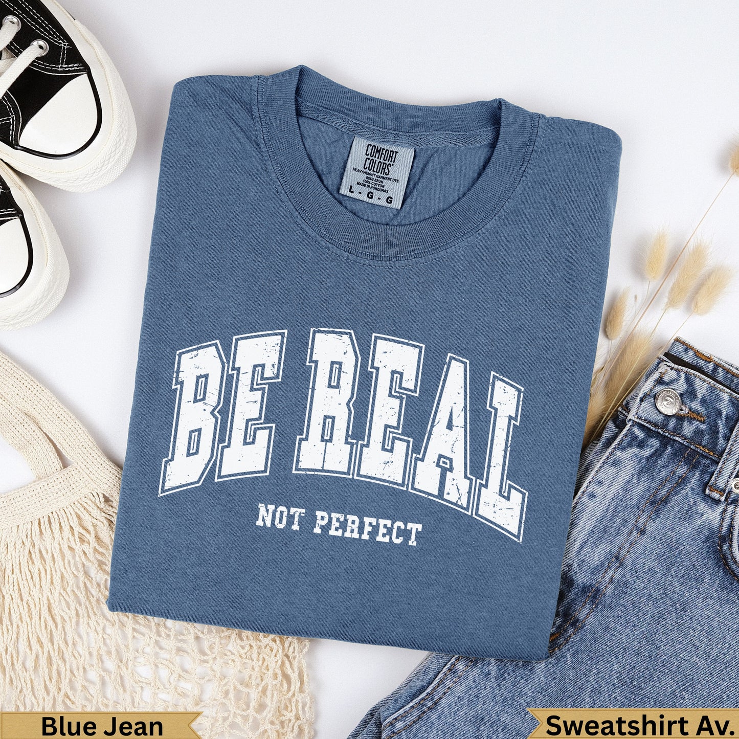 Blue t-shirt with "BE REAL NOT PERFECT" text, garment dyed.