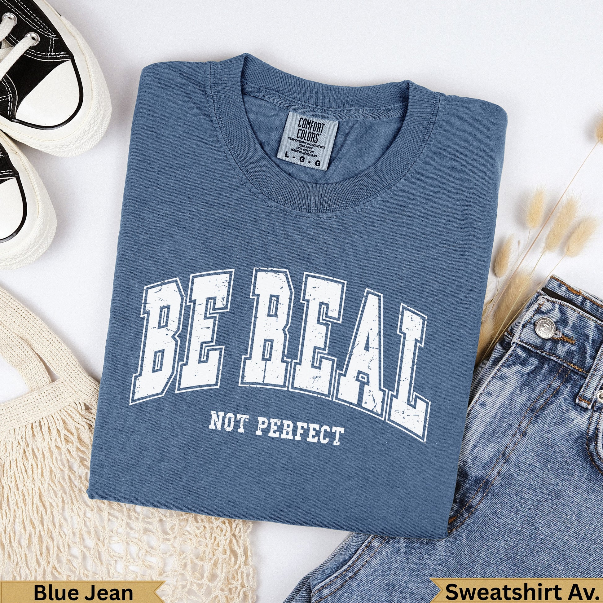 Blue t-shirt with "BE REAL NOT PERFECT" text, garment dyed.